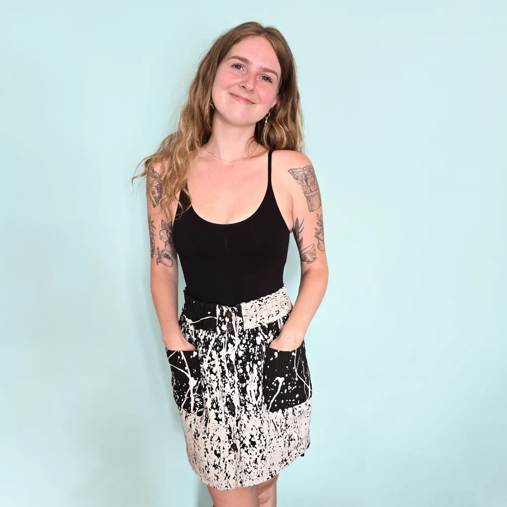 Woman wearing skirt with paint splatter design.