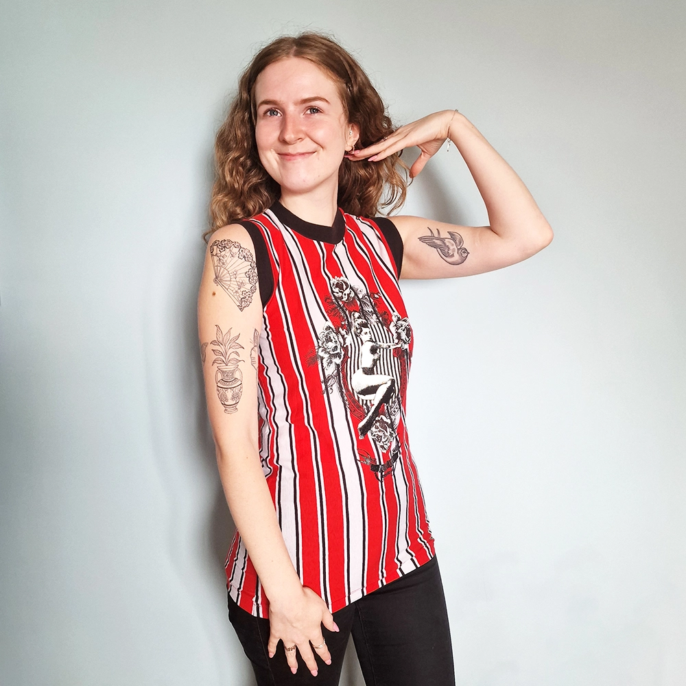 young woman with tattoos modelling a striped vest 