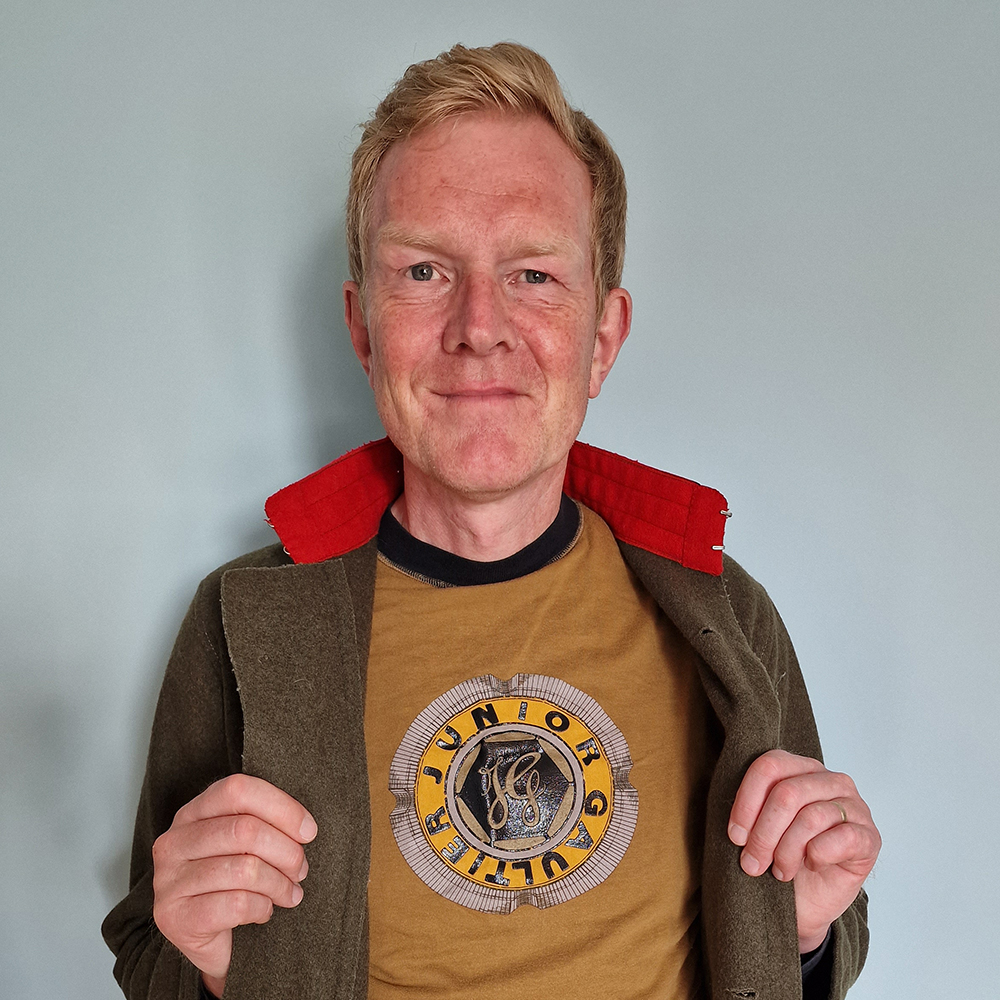 Man wearing a military jacket over a t-shirt from the Fantômas collection.
