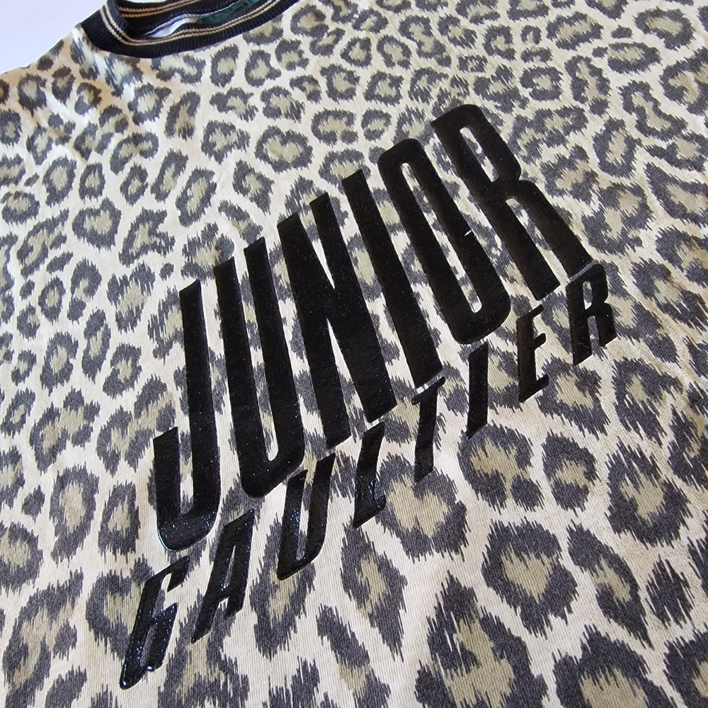 Close up of the Junior Gaultier logo on a leopard print background