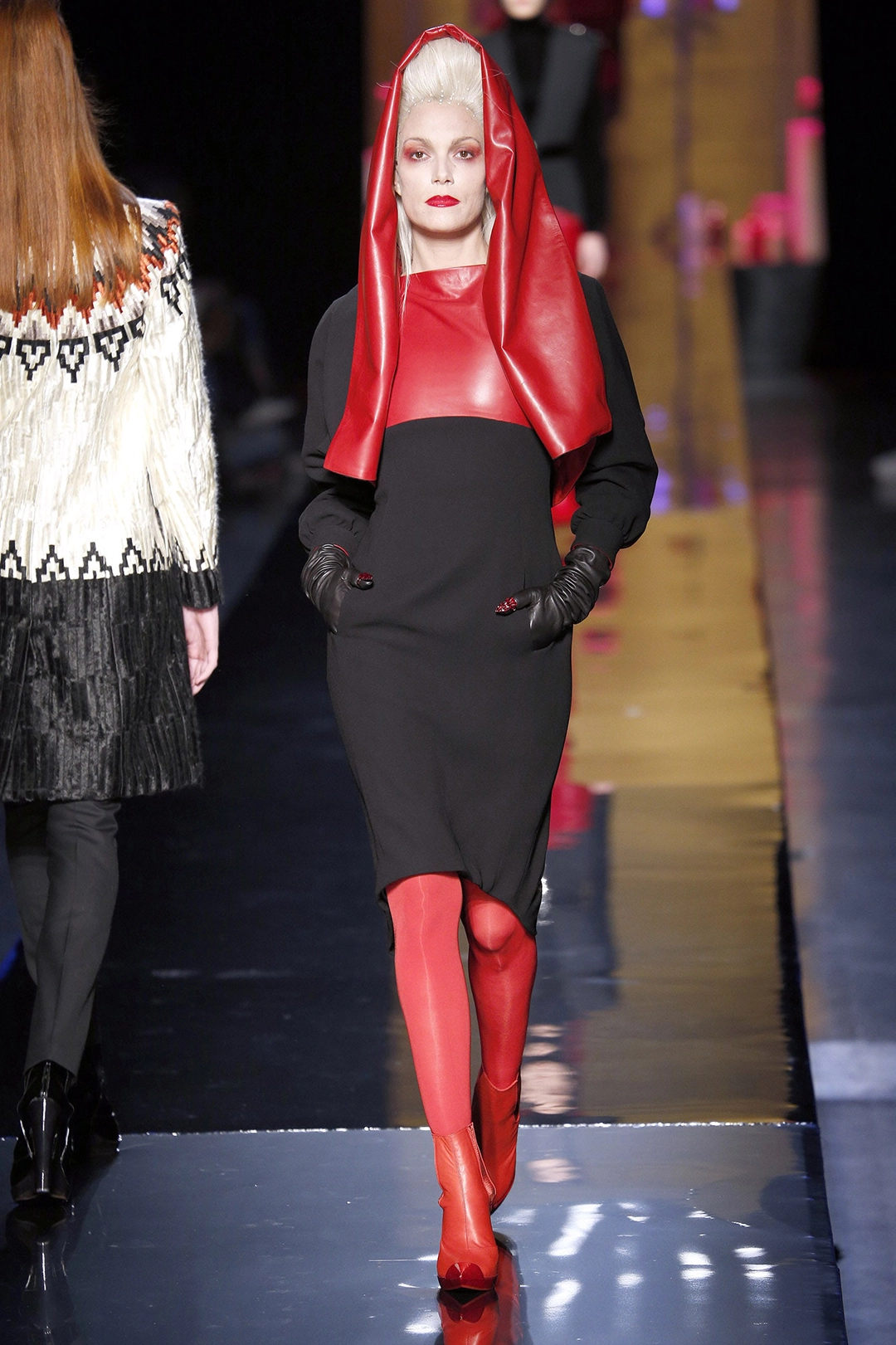 Bleached blonde woman wearing red leather hood over black dress