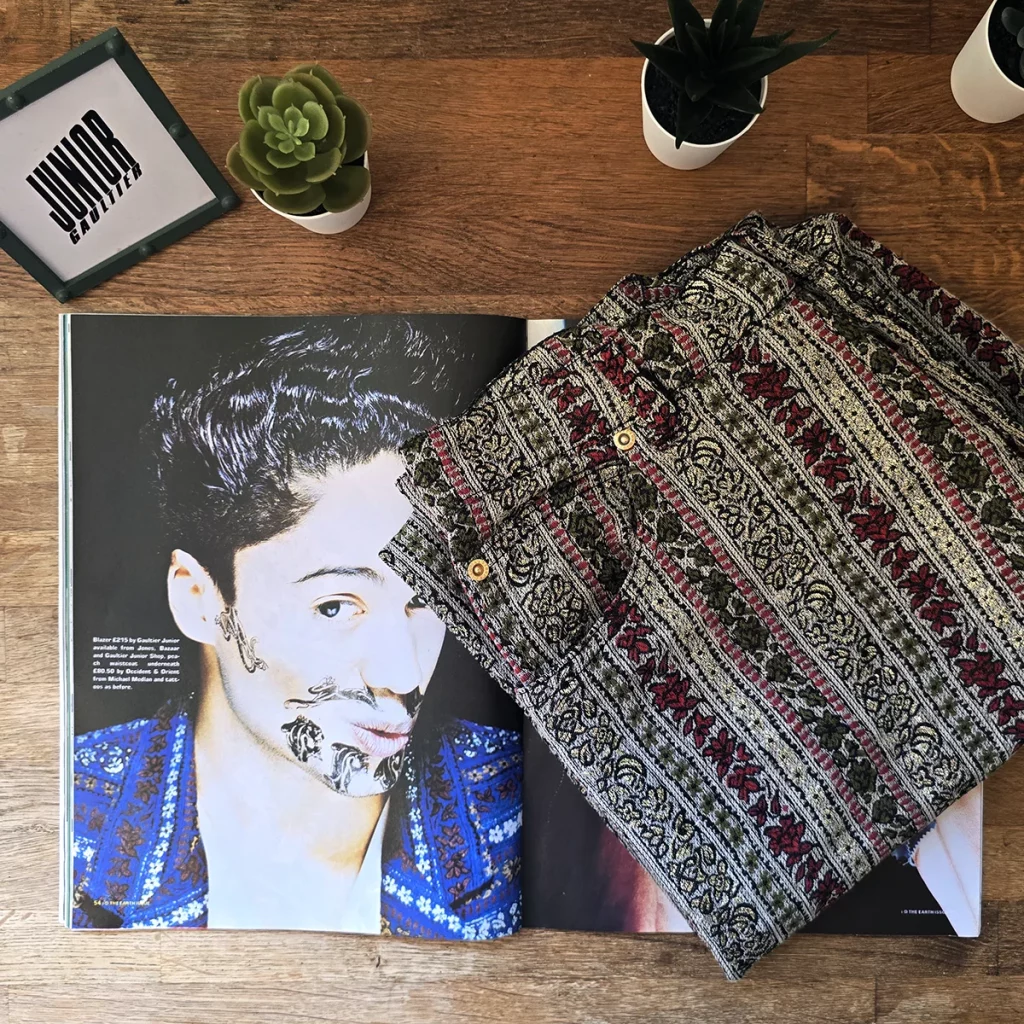 Junior Gaultier Western Baroque trousers displayed alongside a February 1989 issue of i-D Magazine, highlighting the intricate woven pattern featured in the Spring/Summer 1989 collection.