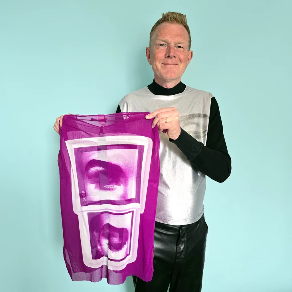 Person holding up a top with two eyes printed on it
