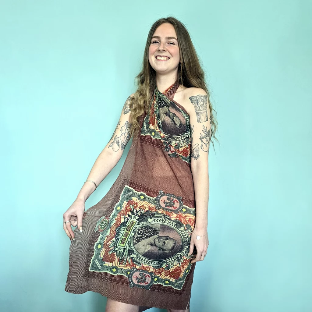 Young woman wearing sarong with graphic of Jean Paul Gaultier dressed as a circus strongman