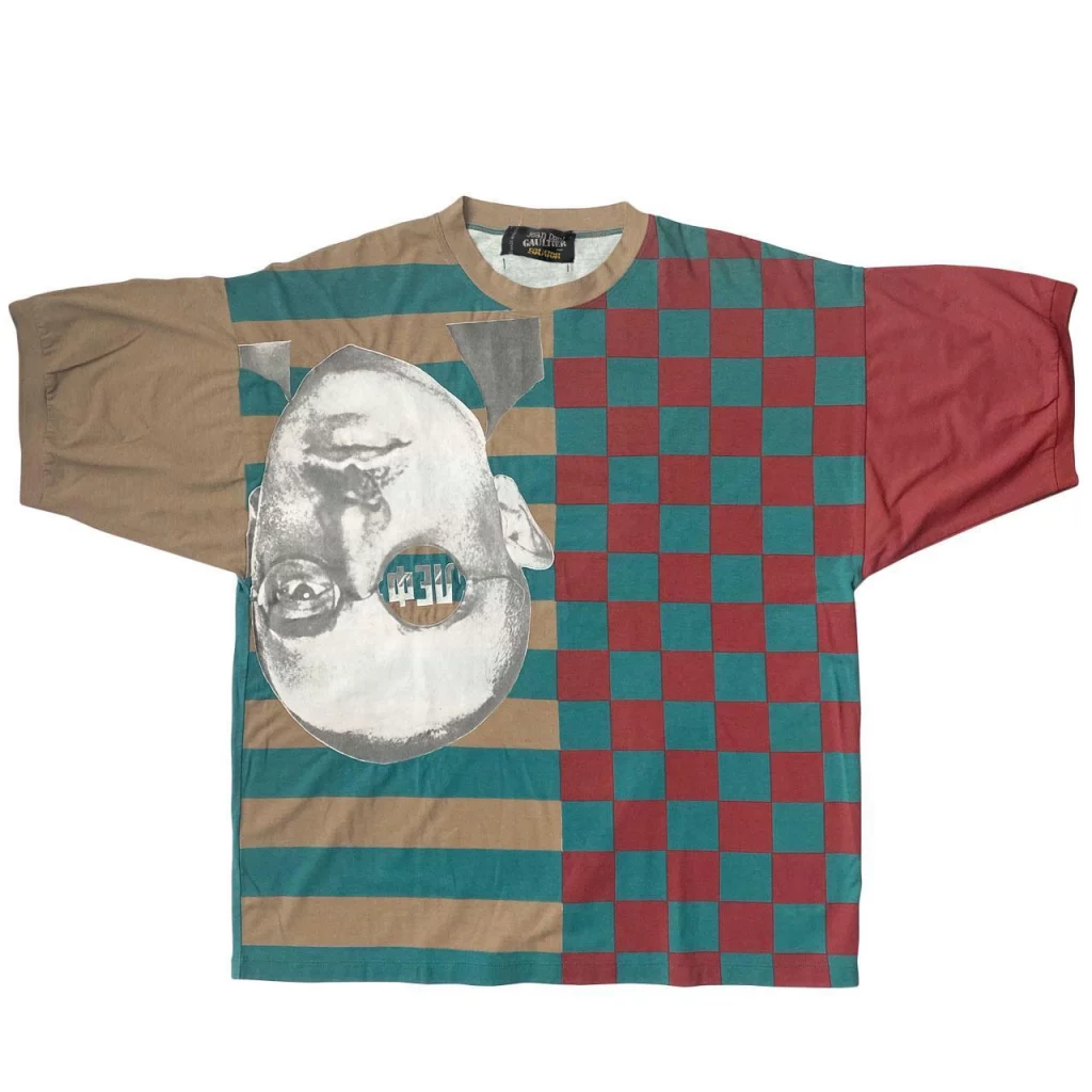 A checked and striped T-shirt with an upside-down  image of a man's head.