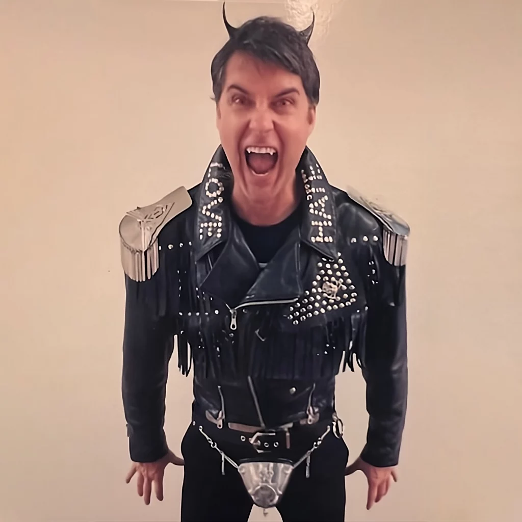 Man wearing fringed leather jacket with silver studs.