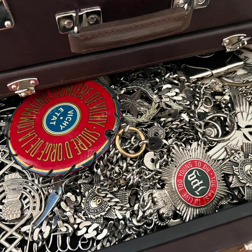 An open drawer showing a mass of silver brooches and chains.