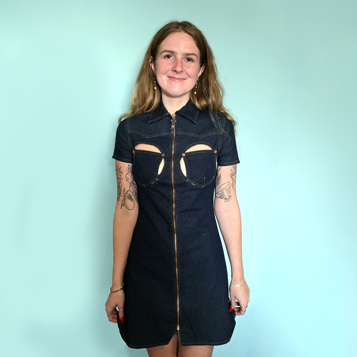 Lady wearing a denim dress with cutout breast pockets