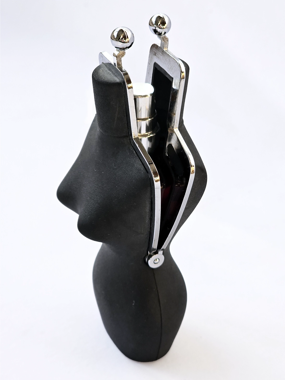 An open case shaped like a women's silhouette with a bottle inside. 